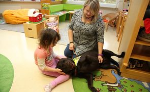 Caritas-Mitarbeiterin Sandra Kainzinger und Therapiehund Joey bei der Arbeit.